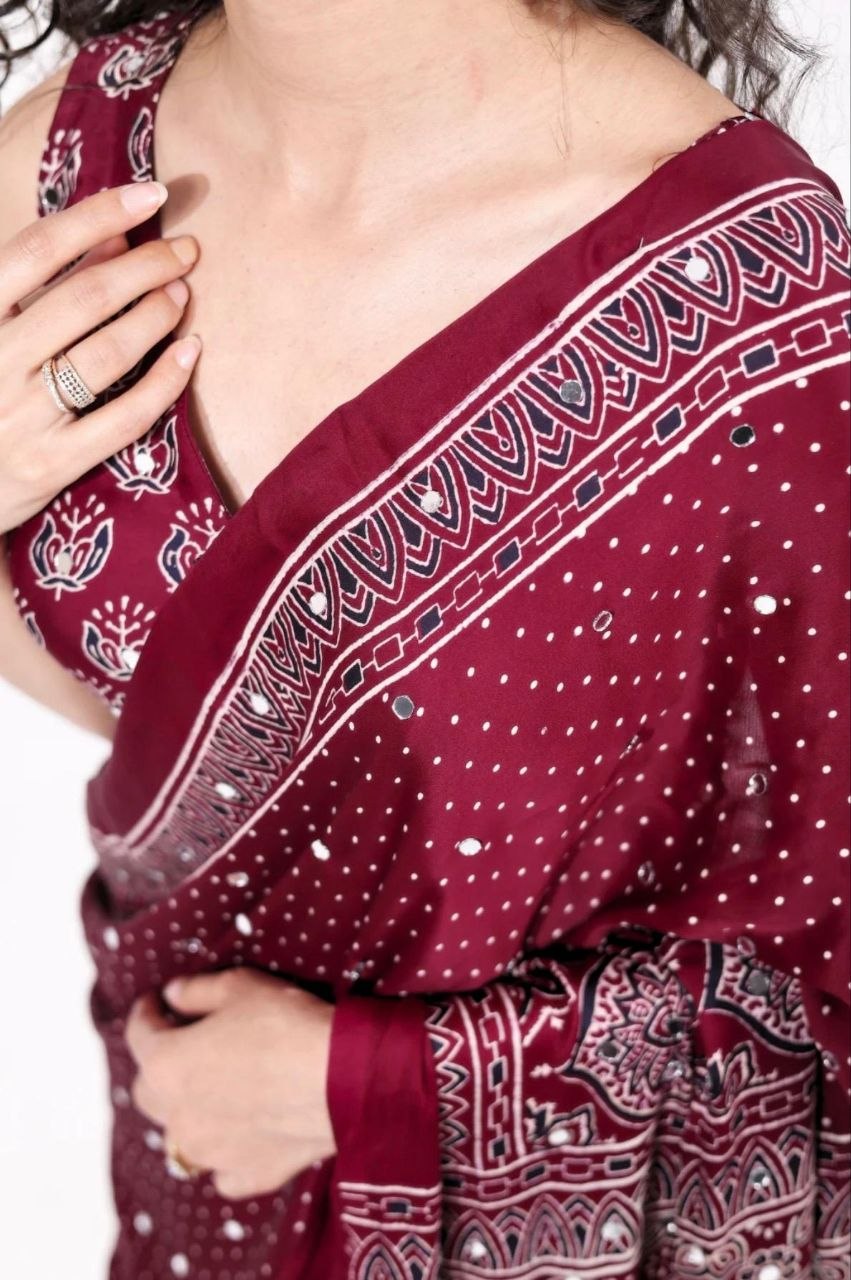 Maroon Ajrakh Print Mirror Work Saree With Designer Border & Tassels With Matching Blouse Piece